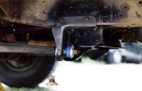 1979 Ford Bronco - Vehicle suspension linkage with a blue polyurethane bushing is visible.