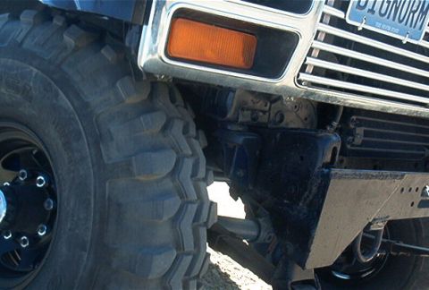 1986 Ford Bronco - A close-up view of the front of a modified off-road vehicle, focusing on the tire and grille.