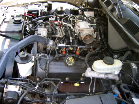 2000 Ford Crown Victoria - Close-up view of a V8 engine bay, showing various components and wiring, with a SuperMotors watermark at the bottom.