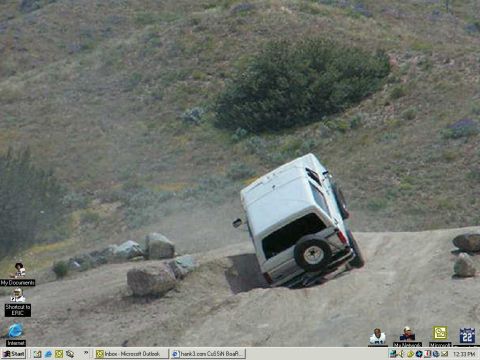 1988 Ford Bronco - Van is tilted on a dirt hill, kicking up dust.
