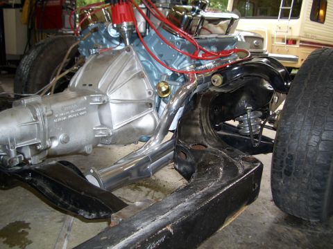 1967 Pontiac GTO - The engine and transmission are partially assembled, showing the V8 engine block, exhaust manifolds, and drivetrain components.