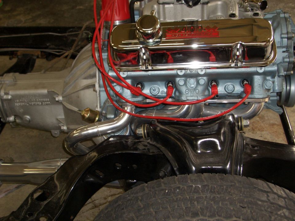 Rebuilt Pontiac 400 V8 in bare chassis with chrome valve cover and red plug wires