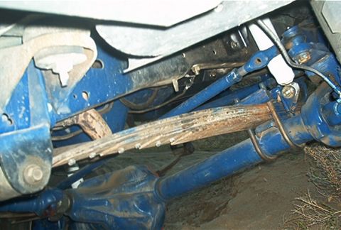 1986 Ford Bronco - Close-up view of a vehicle's suspension system, showing blue-painted parts and leaf springs.