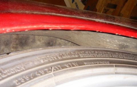 1991 Ford Taurus - Close-up of a red fender arch above a tire, showing tire size information.