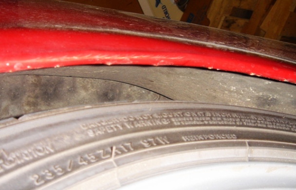 Red fender arch over tire with visible tire size 235/45ZR17