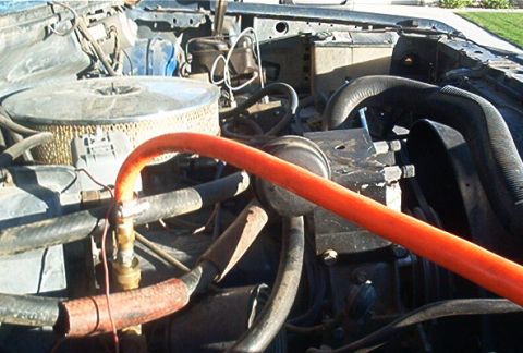 1986 Ford Bronco - Close-up view of the engine bay, showing various hoses and the air filter assembly.
