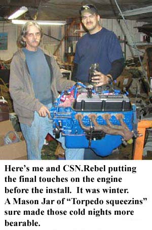 1988 Ford Bronco - Two men are shown working on a blue engine, with one holding a jar.