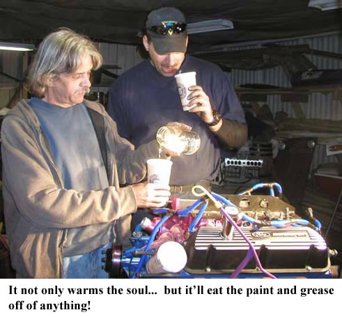 Engine block with blue and purple hoses, two men pouring liquid