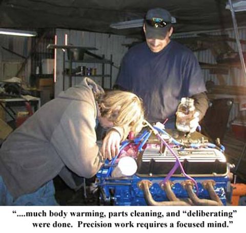 1988 Ford Bronco - Two individuals are actively engaged in an engine rebuild process in a workshop setting.