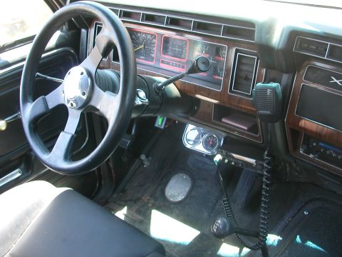 1984 Ford Bronco - Interior view of a vehicle, an aftermarket steering wheel and dashboard.