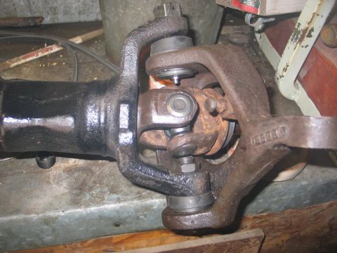 1995 Ford Bronco - Close-up view of a vehicle's front axle driveshaft U-joint and knuckle assembly.