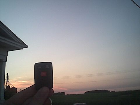 1994 Ford Bronco - Holding a car key fob at sunset, with a house and rural landscape in the background.