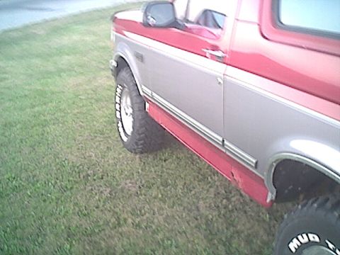1994 Ford Bronco - This two-tone Ford Bronco is shown from the side, with its front fender and door visible.