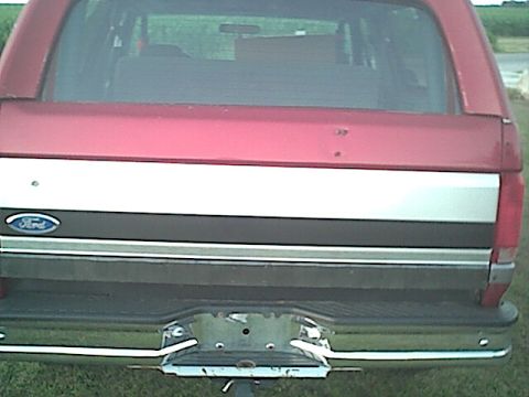 1994 Ford Bronco - Rear view of a red 1994 Ford Bronco, a distinctive silver and black stripe across the tailgate.