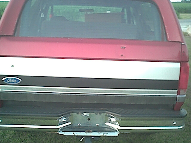 Rear of red 1994 Ford Bronco with silver and black stripe