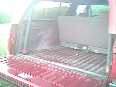 1994 Ford Bronco - Rear interior view of a 1994 Ford Bronco, showing the cargo space and folded rear seat.