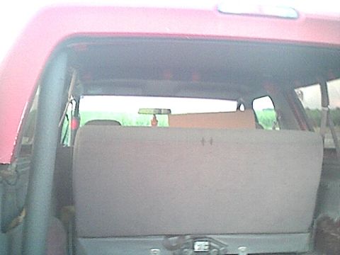 1994 Ford Bronco - Interior view of a red SUV with rear seats folded and a cardboard box placed on top.
