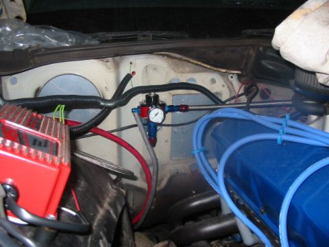 1985 Ford LTD Crown Victoria - Close-up view of engine bay components, including a fuel pressure regulator and ignition system.