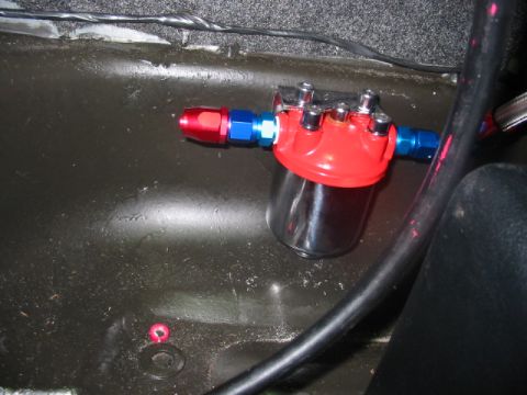 1985 Ford LTD Crown Victoria - Aftermarket fuel filter assembly with red and blue fittings is visible inside a vehicle.