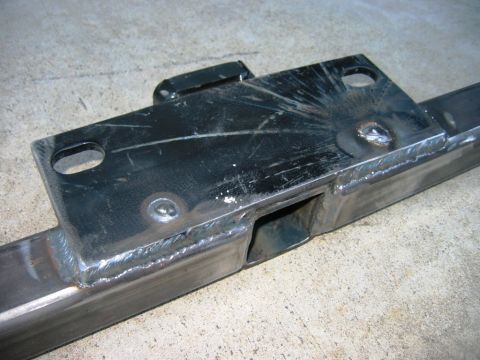 1985 Ford Bronco - A close-up view of a welded steel tow hitch receiver, showing its construction and mounting points.
