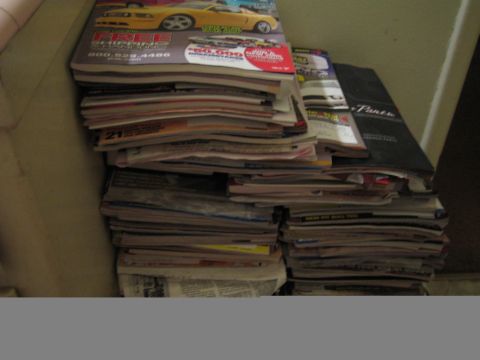 1990 Ford Bronco - photo of a large pile of car magazines and newspapers, not a technical document.