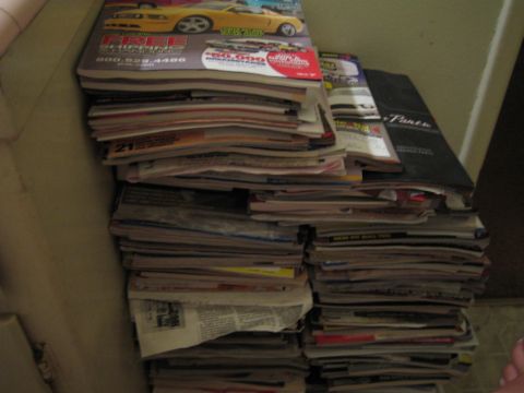 1990 Ford Bronco - photo of a large pile of car magazines and newspapers, not a technical document.