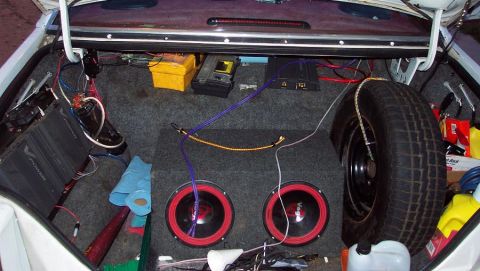 1985 Ford LTD Crown Victoria - The trunk of a vehicle is shown with a custom audio system installed, including subwoofers and amplifiers.