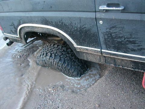1984 Ford Bronco - This 1984 Ford Bronco is stuck in the mud, with its rear tire submerged.