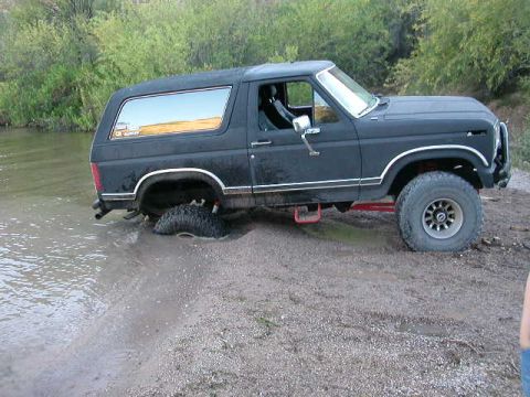 1984 Ford Bronco - This Ford Bronco appears to be stuck in shallow water and mud.