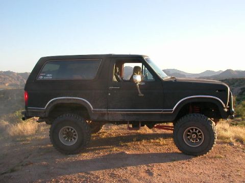 1984 Ford Bronco - This lifted 1984 Ford Bronco is parked on a dirt road in a mountainous, arid landscape.