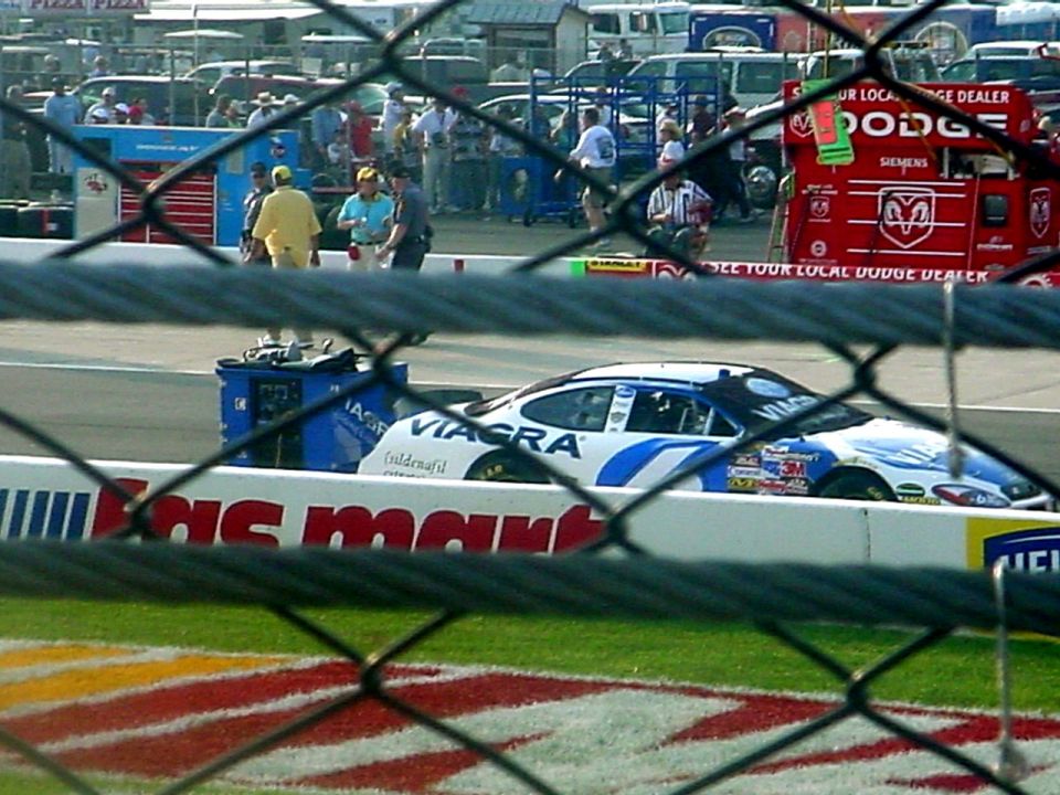 Side view of a white and blue NASCAR race car with Viagra livery on a track