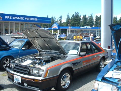 1999 Ford Crown Victoria - Silver 1979 Ford Mustang Pace Car on display at Harris Ford, hood up.