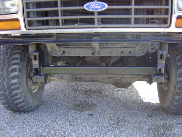 1986 Ford F-150 - Close-up of the front end of a 1986 Ford F-150, highlighting its grille and suspension modifications.