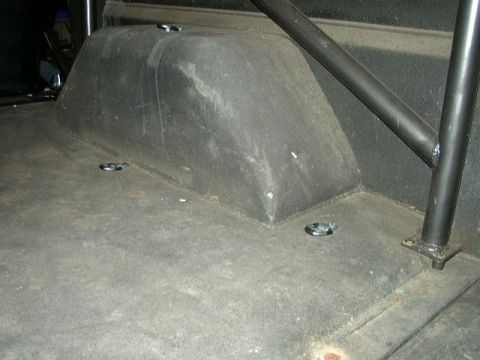 1995 Ford Bronco - The rear interior of a vehicle, tie-down points and a partial roll cage structure.