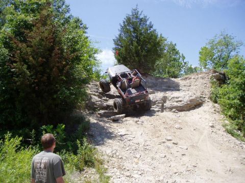 1992 Ford Bronco - This modified off-road vehicle navigates a challenging rocky terrain on a sunny day.