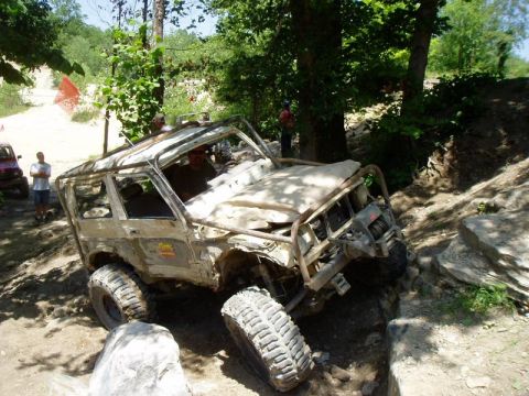 1992 Ford Bronco - An off-road vehicle navigates a challenging rocky course with spectators nearby.