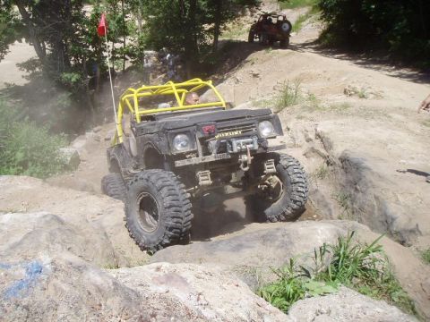 1992 Ford Bronco - Modified Suzuki Samurai navigates a rocky trail, with another off-road vehicle visible in the background.