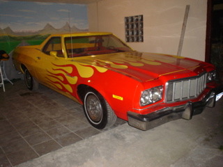 1974 Ford Ranchero - A 1974 Ford Ranchero with custom flame paint job is parked indoors.