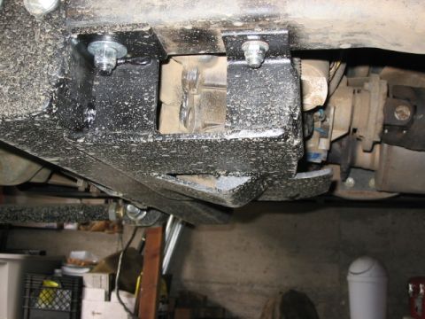 1995 Ford Bronco - Close-up view of the undercarriage, focusing on the transfer case and protective skid plate with visible mounting hardware.