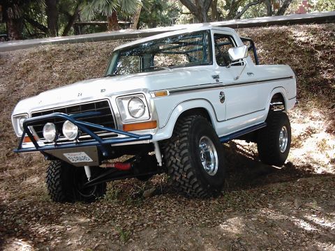 1978 Ford Bronco - A modified 1978 Ford Bronco navigates an uneven terrain with its front wheels turned.