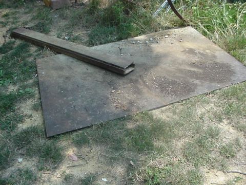 1988 Ford Bronco - A collection of metal objects lies on the grass, with a watermark at the bottom right.