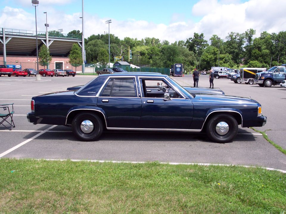 Side view of a dark blue sedan with chrome trim and hubcaps