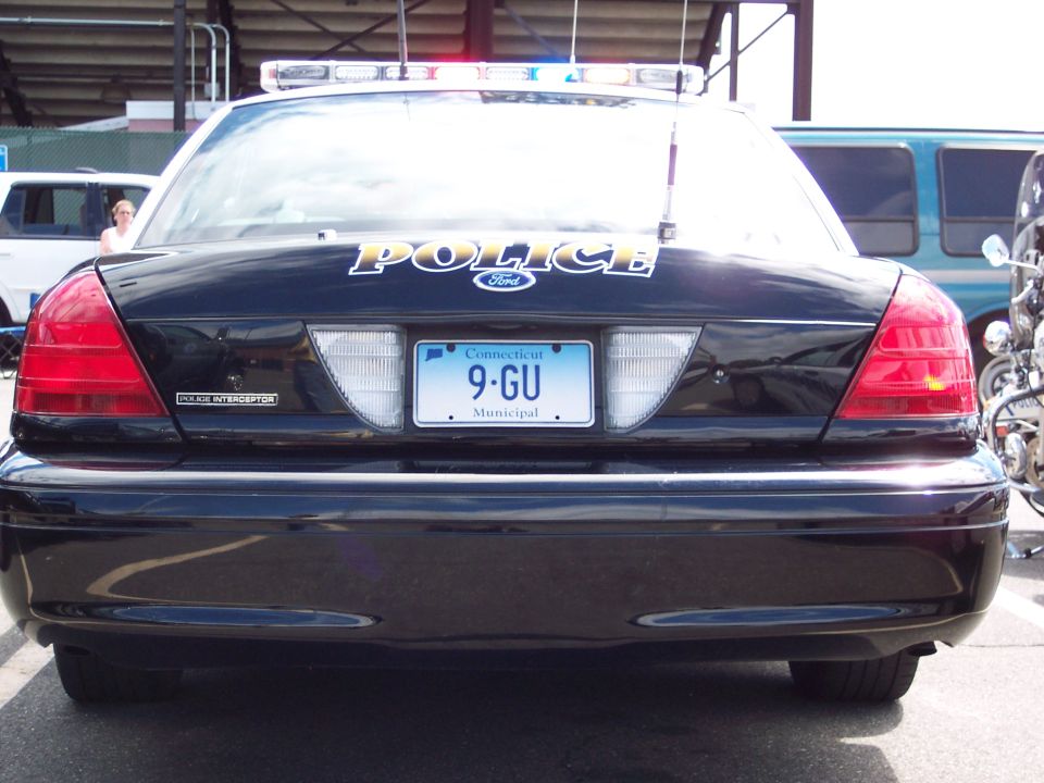 Black 2001 Ford Crown Victoria police car rear view, with 'POLICE' text and Connecticut license plate