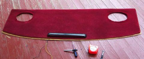 1985 Ford LTD Crown Victoria - A red carpeted dashboard piece is shown with tools and a measuring tape on a wooden floor.