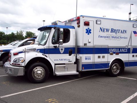 2001 Ford Crown Victoria - A New Britain EMS ambulance is parked next to a police vehicle.