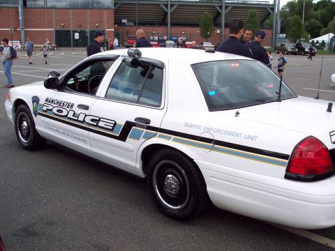 2001 Ford Crown Victoria - A white 2001 Ford Crown Victoria police car is parked outdoors, showing its "MANCHESTER POLICE" livery and "TRAFFIC ENFORCEMENT UNIT" marki…