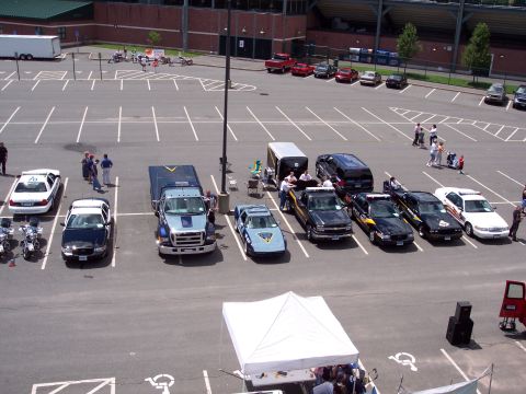 2001 Ford Crown Victoria - A collection of police vehicles, including a 2001 Ford Crown Victoria, are displayed in a parking lot during an event.