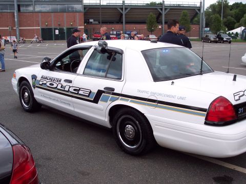 2001 Ford Crown Victoria - Manchester Police car, a Ford Crown Victoria, is seen from the side with its markings visible.