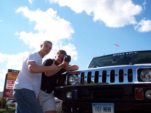 2001 Ford Crown Victoria - Men stand next to a Hummer H2, which has a 'POLICE' decal on its windshield.