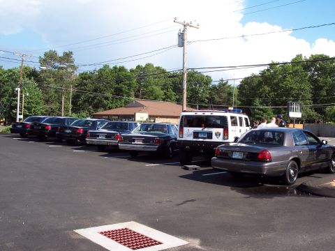 2001 Ford Crown Victoria - Several police vehicles, including a Ford Crown Victoria, are parked in a lot on a cloudy day.